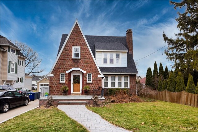 tudor home featuring a front yard and a garage