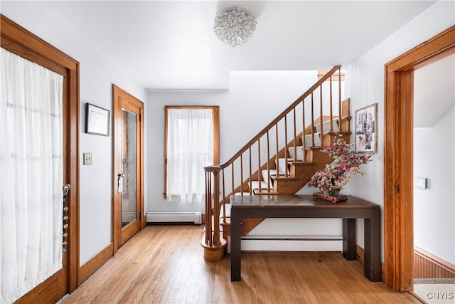 foyer entrance with light hardwood / wood-style flooring and baseboard heating