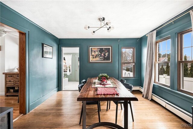 1 Alden Ave, Auburn, NY 13021 - dining area with a baseboard radiator, light wood-type flooring, and a chandelier