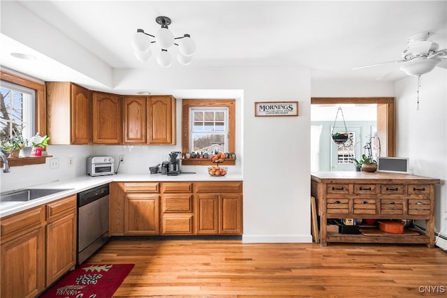 kitchen featuring ceiling fan, dishwasher, sink, and light wood-type flooring