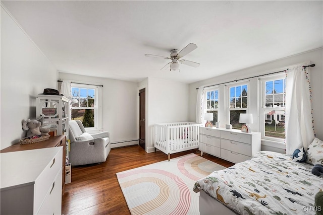 bedroom featuring ceiling fan, a baseboard radiator, and dark hardwood / wood-style flooring