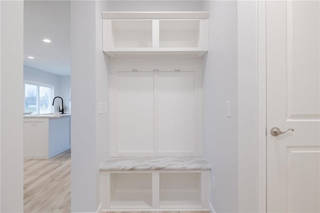 mudroom with sink and light hardwood / wood-style flooring