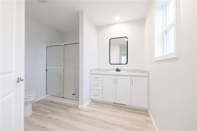 bathroom featuring vanity, hardwood / wood-style flooring, toilet, and walk in shower