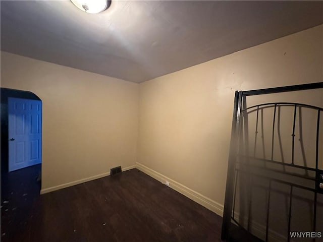 additional living space with dark wood-type flooring