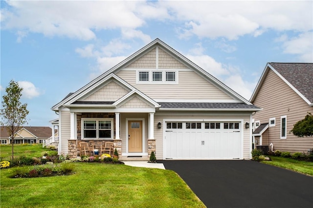 craftsman house featuring a garage and a front lawn