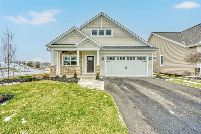 craftsman house featuring a garage and a front yard