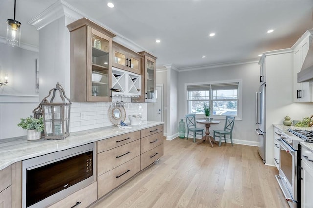 kitchen with white cabinetry, decorative light fixtures, light stone countertops, and appliances with stainless steel finishes