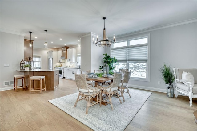 dining room featuring ornamental molding, a healthy amount of sunlight, and an inviting chandelier