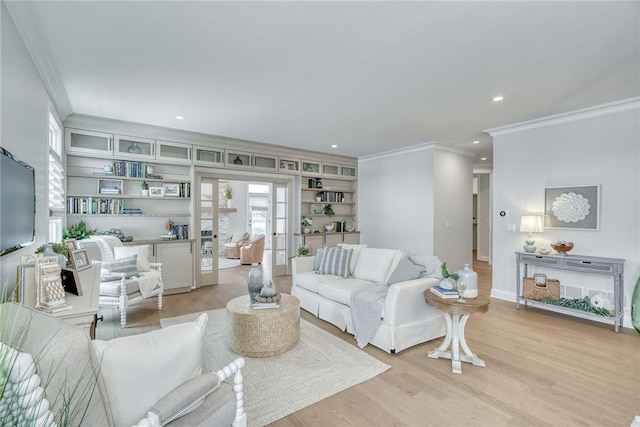 living room with french doors, crown molding, built in shelves, and light wood-type flooring