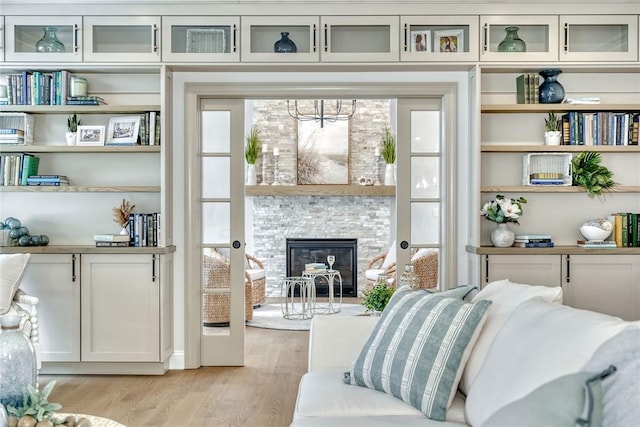 living room with a stone fireplace and light hardwood / wood-style floors