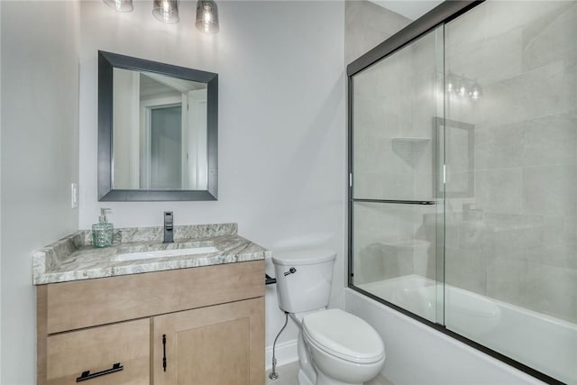 full bathroom featuring vanity, enclosed tub / shower combo, and toilet