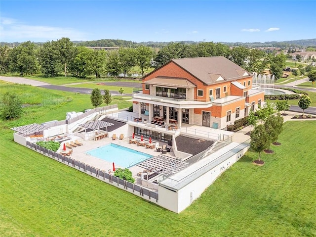 back of house featuring a fenced in pool, a balcony, a yard, and a patio area