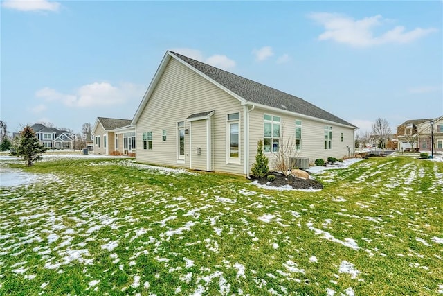 snow covered house with a lawn and central air condition unit