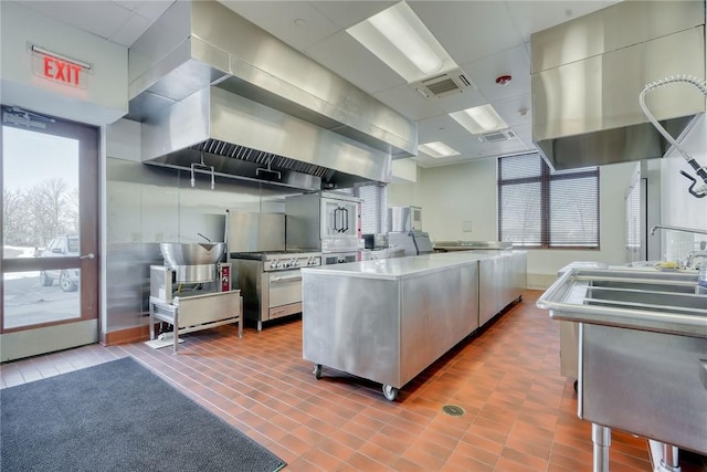 kitchen with light tile patterned flooring, a center island, and high end stove