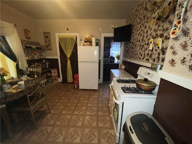 kitchen with white cabinetry and white appliances