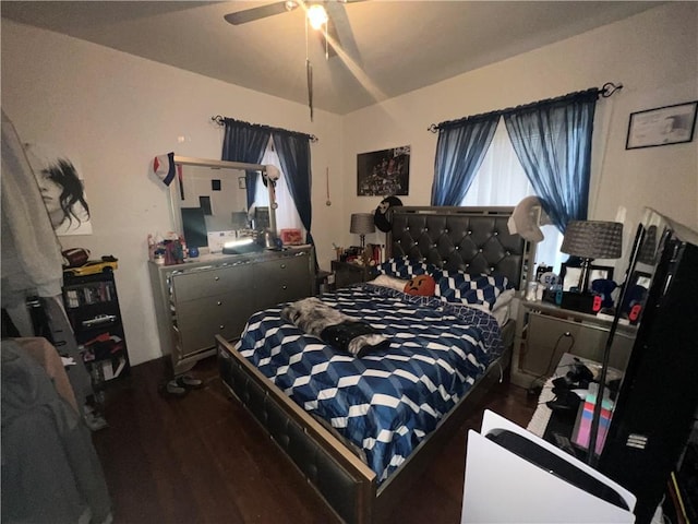 bedroom with ceiling fan, dark wood-type flooring, and vaulted ceiling