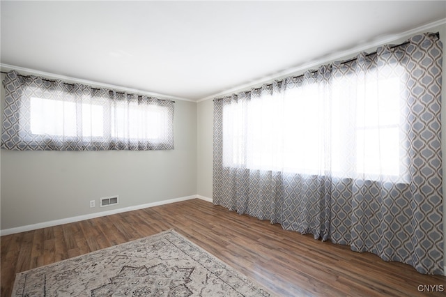 unfurnished room featuring crown molding, hardwood / wood-style floors, and plenty of natural light