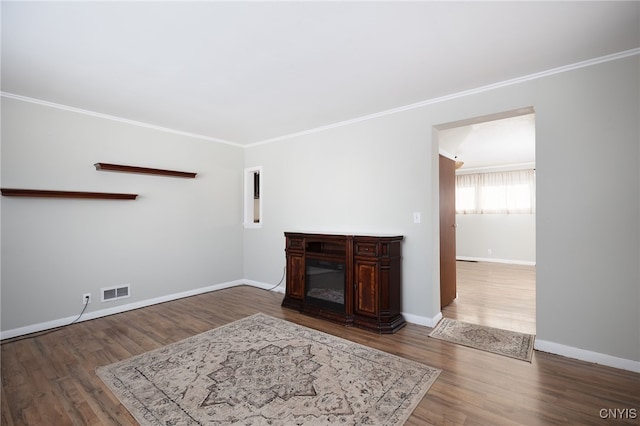 unfurnished living room featuring hardwood / wood-style floors and ornamental molding