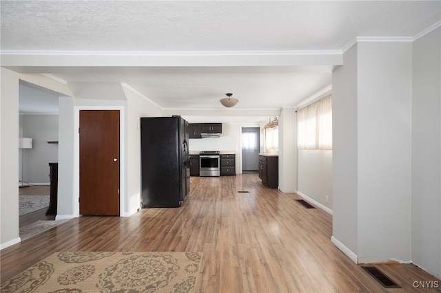 unfurnished living room with wood-type flooring, a textured ceiling, and crown molding