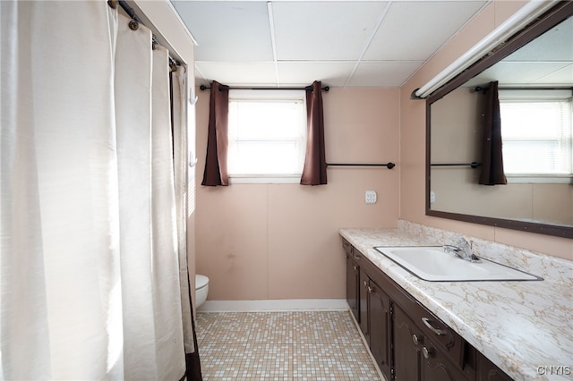 bathroom featuring toilet, vanity, tile patterned floors, and a wealth of natural light