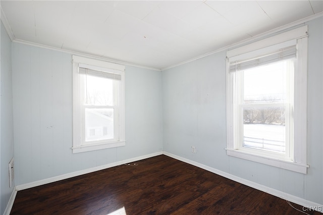 empty room featuring hardwood / wood-style flooring, crown molding, and a wealth of natural light