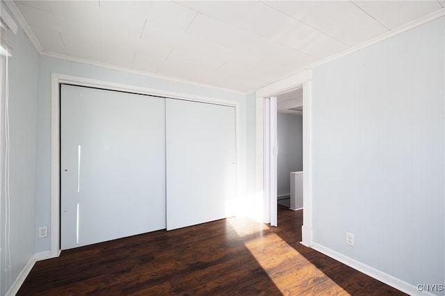 unfurnished bedroom with dark hardwood / wood-style floors and ornamental molding