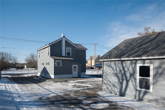 view of snow covered back of property