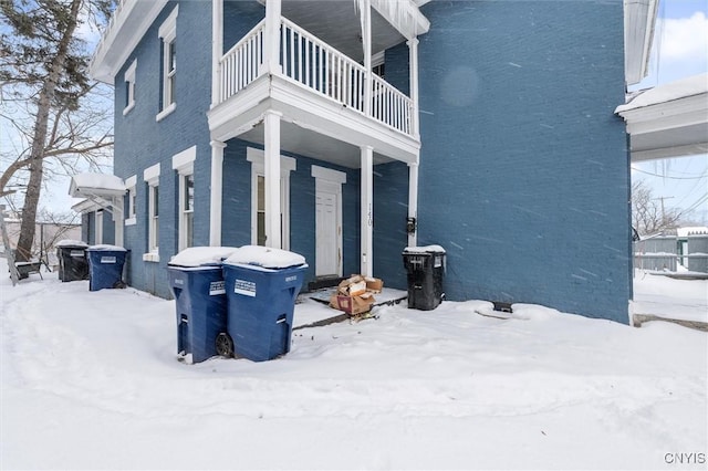 snow covered property featuring a balcony