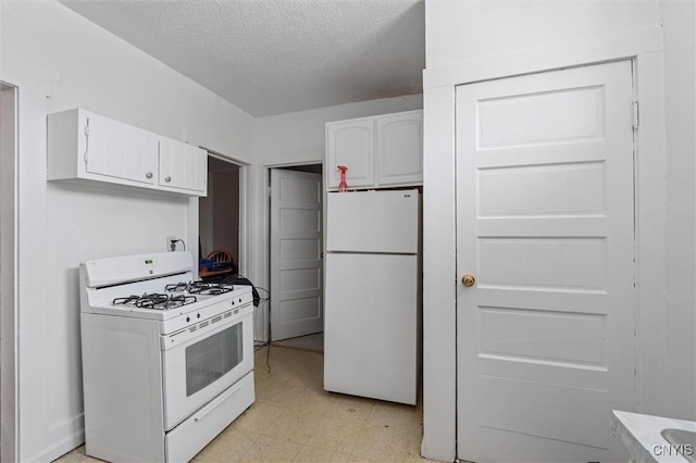 kitchen with a textured ceiling, white cabinets, and white appliances