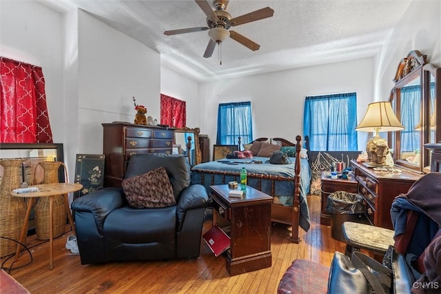 bedroom featuring ceiling fan, a textured ceiling, and light hardwood / wood-style flooring