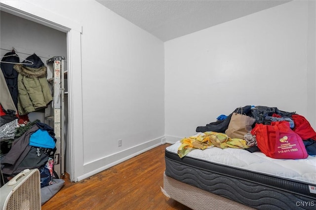 bedroom with wood-type flooring and a textured ceiling