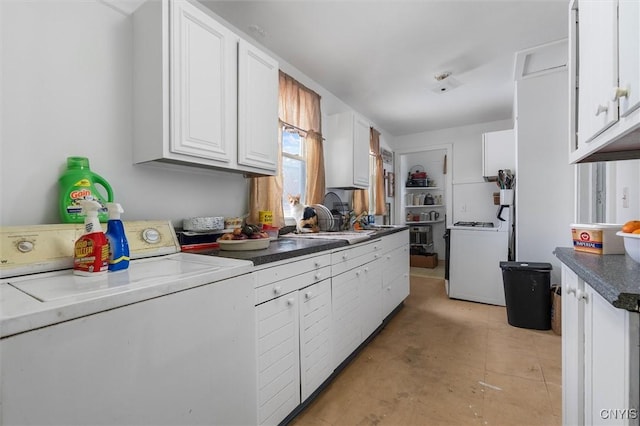 kitchen with washer and clothes dryer, sink, and white cabinets