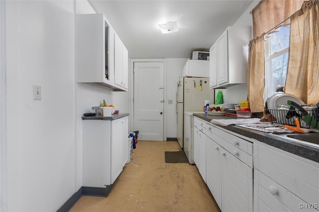 kitchen featuring white fridge and white cabinetry