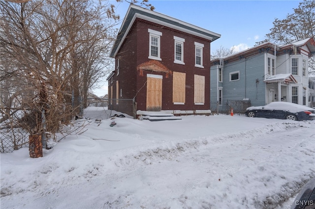 view of snow covered back of property