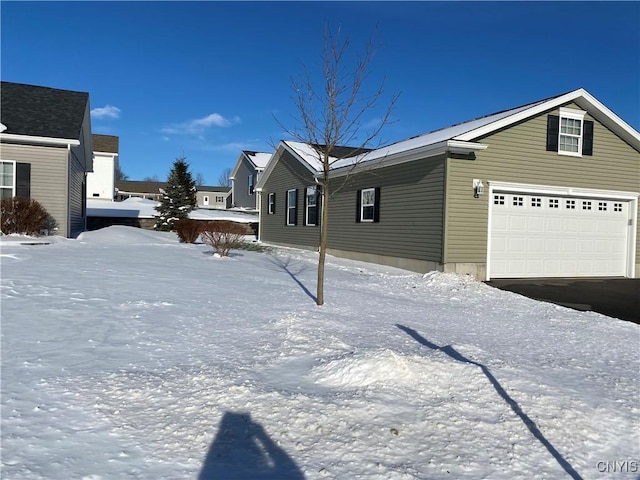 view of snowy exterior featuring a garage