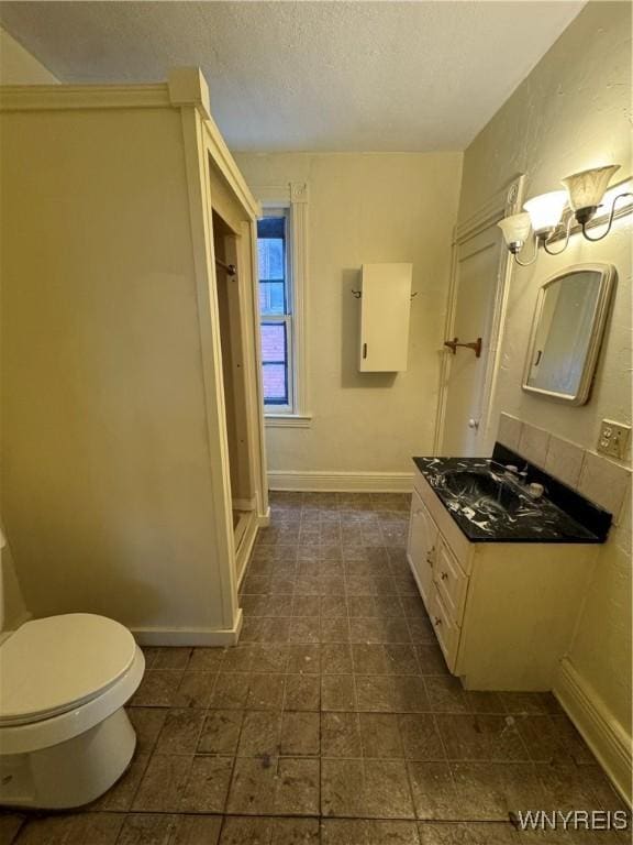 bathroom with vanity, a textured ceiling, and toilet