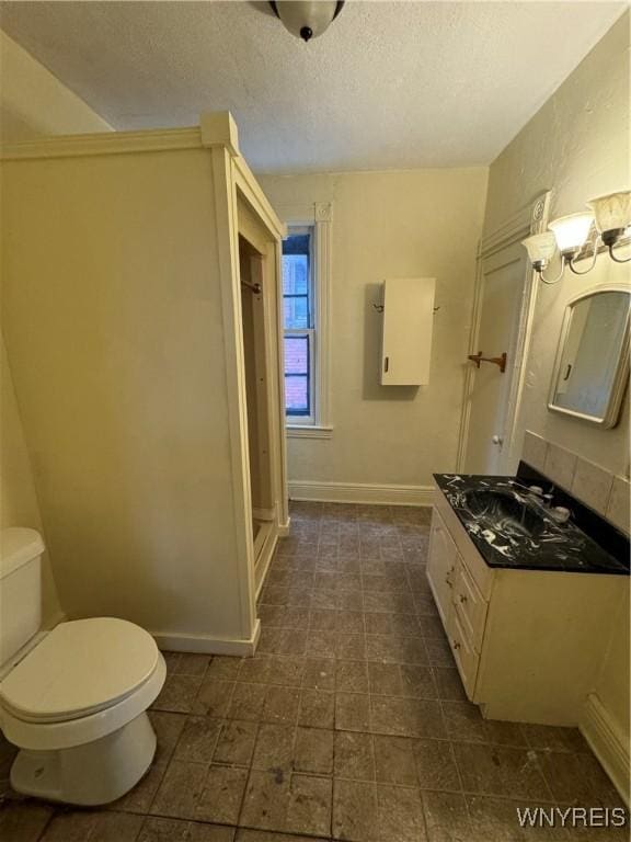 bathroom with vanity, a textured ceiling, and toilet