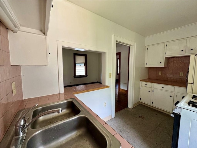 kitchen with white cabinetry, white appliances, sink, and tasteful backsplash