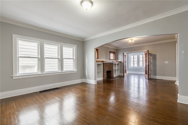 unfurnished living room featuring dark hardwood / wood-style flooring, a brick fireplace, and ornamental molding