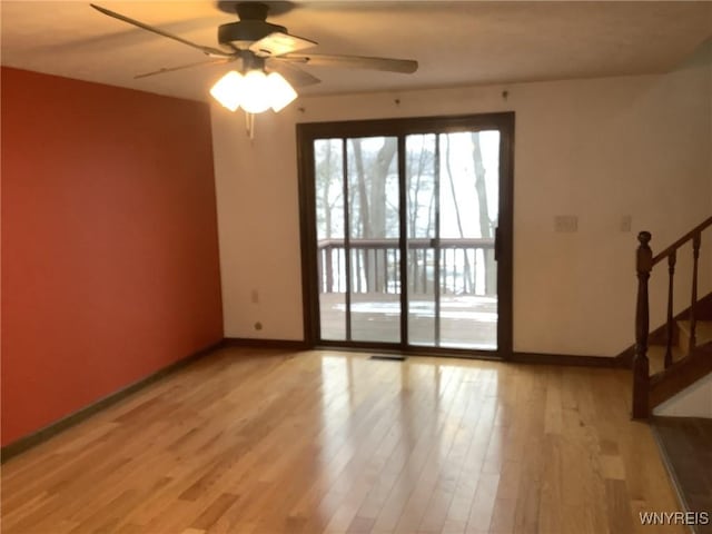 empty room with ceiling fan and light hardwood / wood-style floors