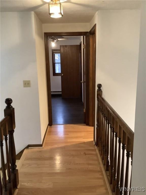 corridor featuring hardwood / wood-style floors and a baseboard radiator