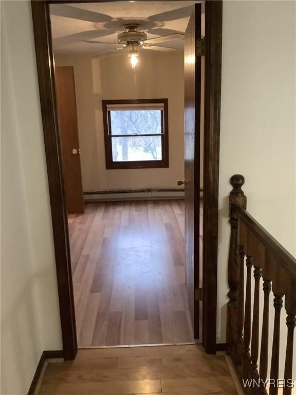 hallway featuring light wood-type flooring and a baseboard radiator