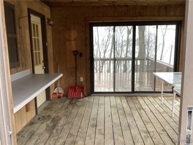 interior space with wood walls, a wealth of natural light, and light hardwood / wood-style flooring