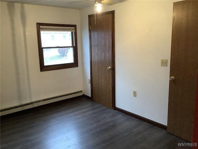 unfurnished room featuring dark hardwood / wood-style floors, ceiling fan, and a baseboard heating unit