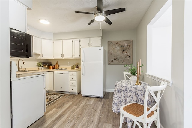 kitchen featuring white appliances, sink, light hardwood / wood-style flooring, ceiling fan, and white cabinetry