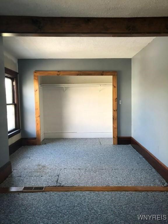 unfurnished room featuring a textured ceiling