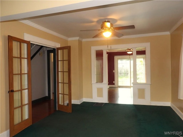 empty room with dark colored carpet, french doors, ceiling fan, and ornamental molding