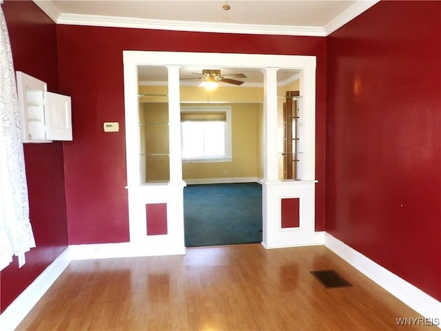 empty room with hardwood / wood-style floors, ceiling fan, and crown molding