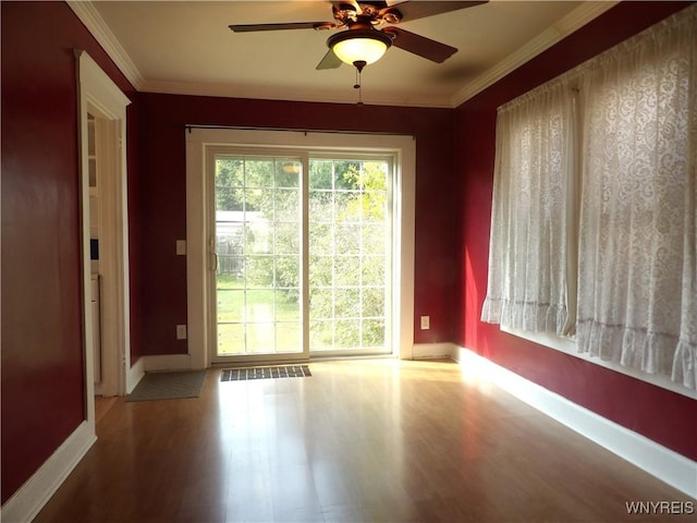 empty room featuring ceiling fan, hardwood / wood-style floors, and crown molding