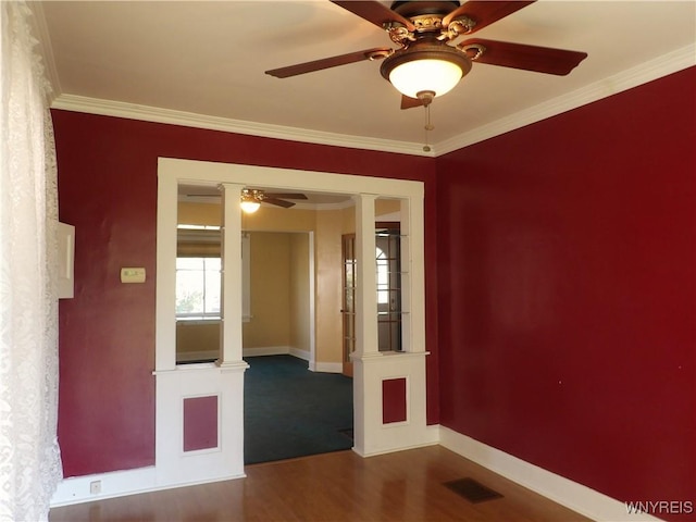 unfurnished room with ornate columns, ceiling fan, dark hardwood / wood-style floors, and ornamental molding